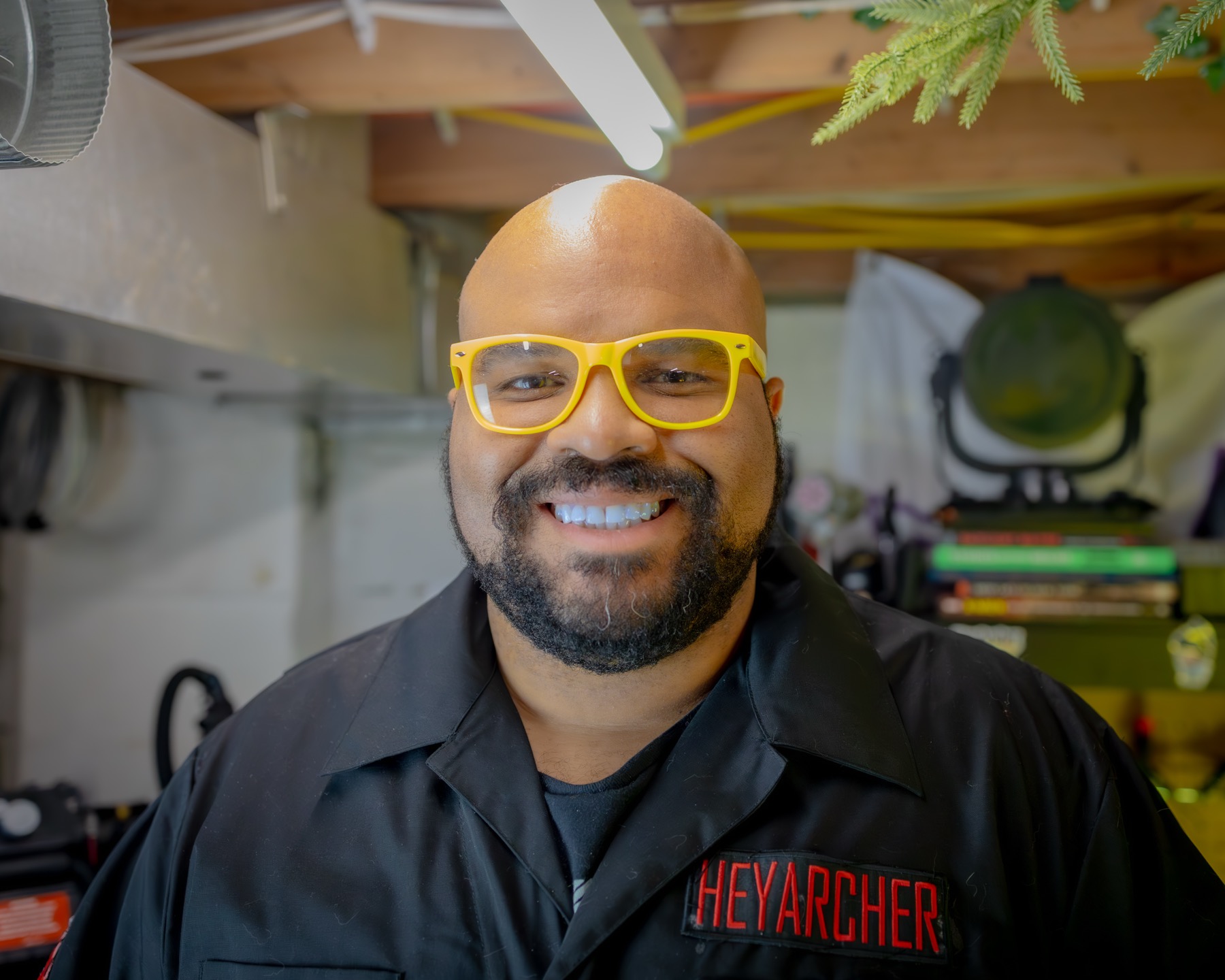 Archer smiling in yellow glasses and black flight suit