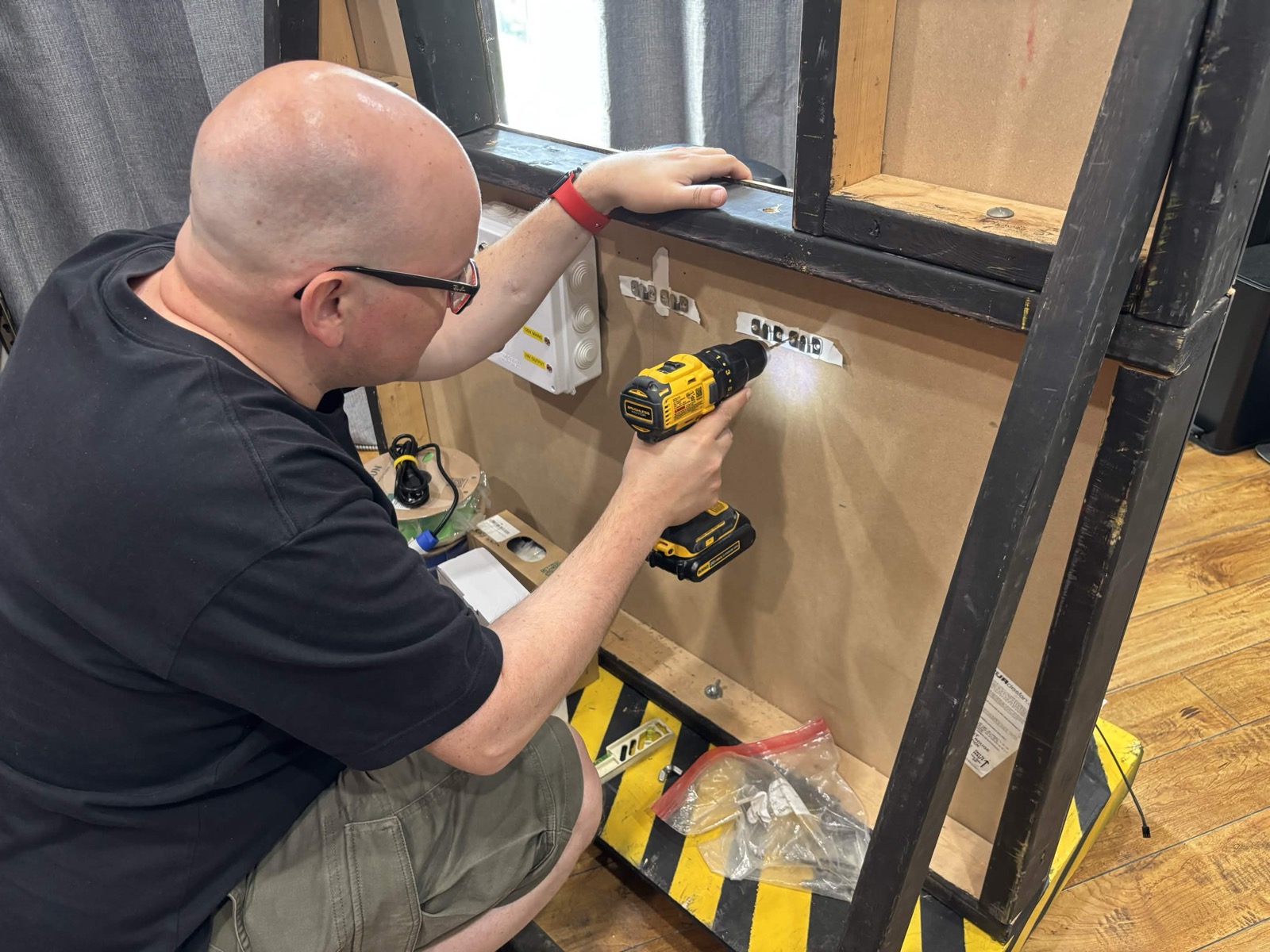Builder drilling into a wall panel for a Capital Ghostbusters build