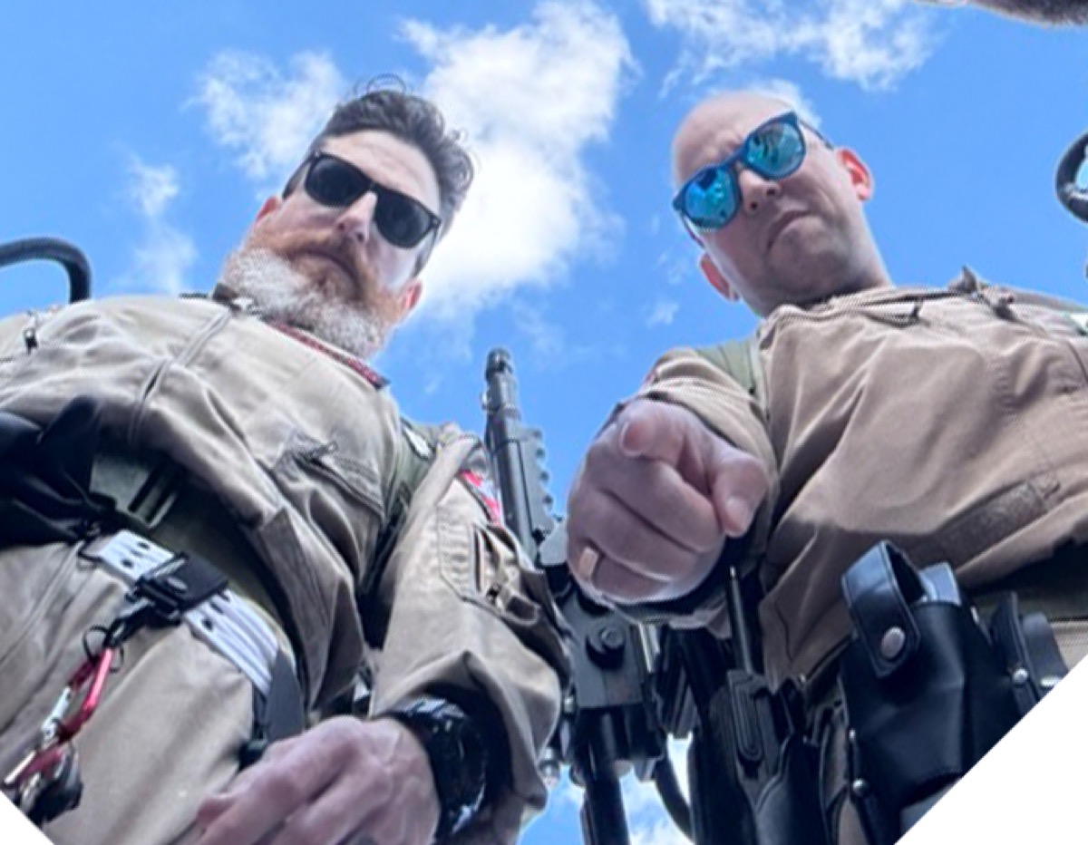 Ryan McFonz and Renel of the Capital Ghostbusters photographed from a low angle in Ghostbusters gear