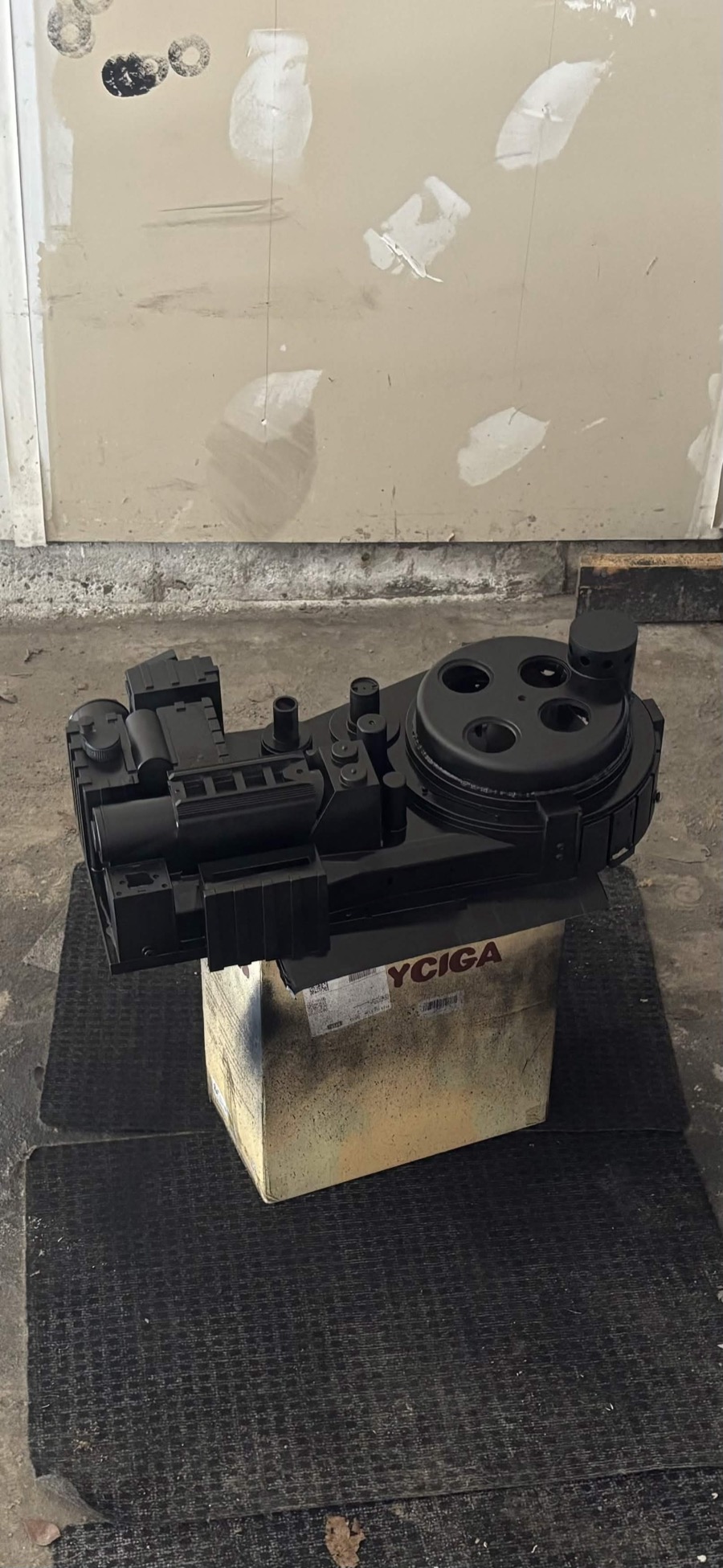 Black proton pack shell sitting on a box in a workshop