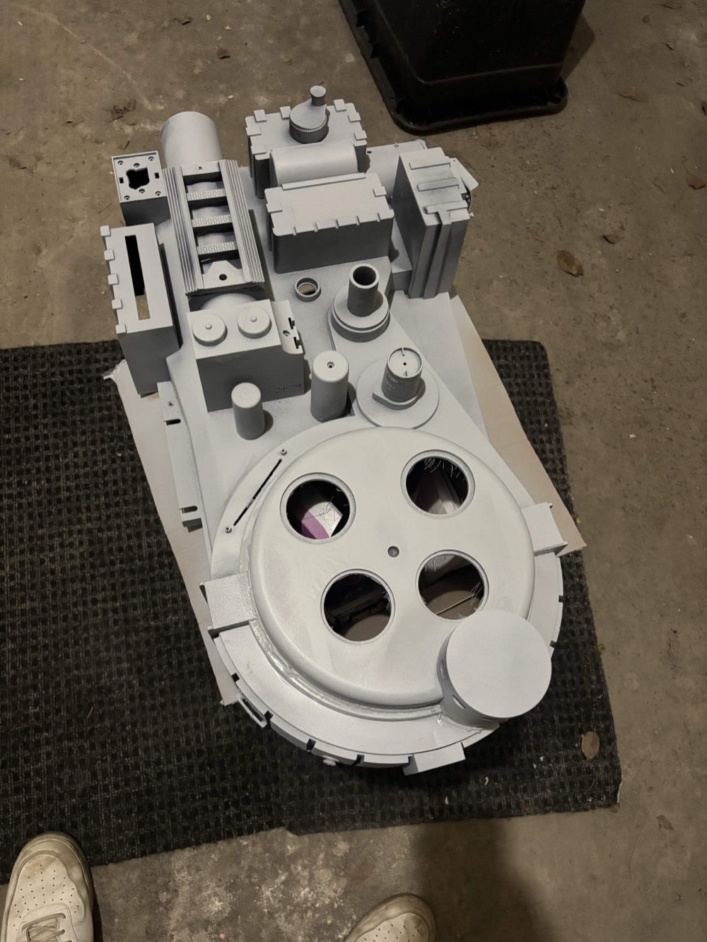 Primed gray proton pack shell on the floor