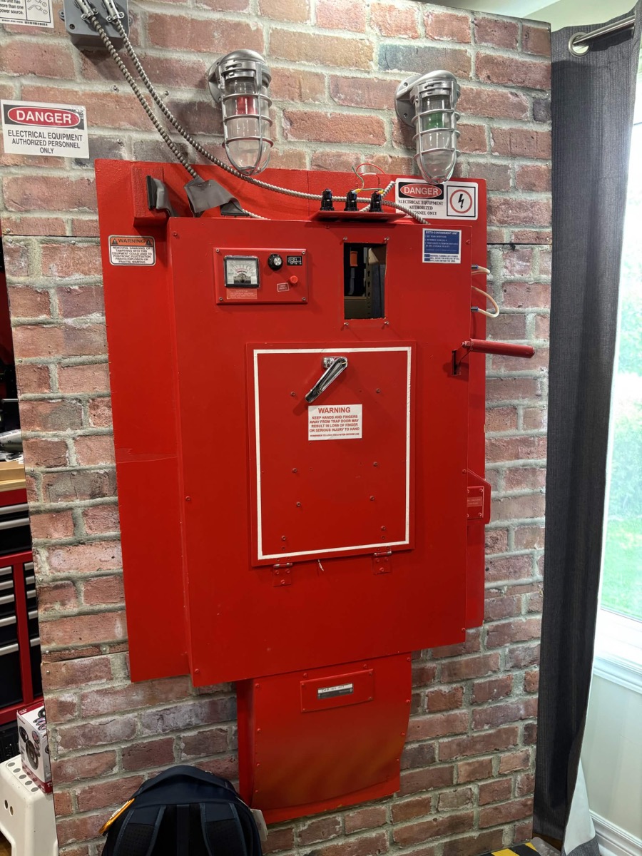 Large red Ghostbusters-inspired containment panel on a brick wall