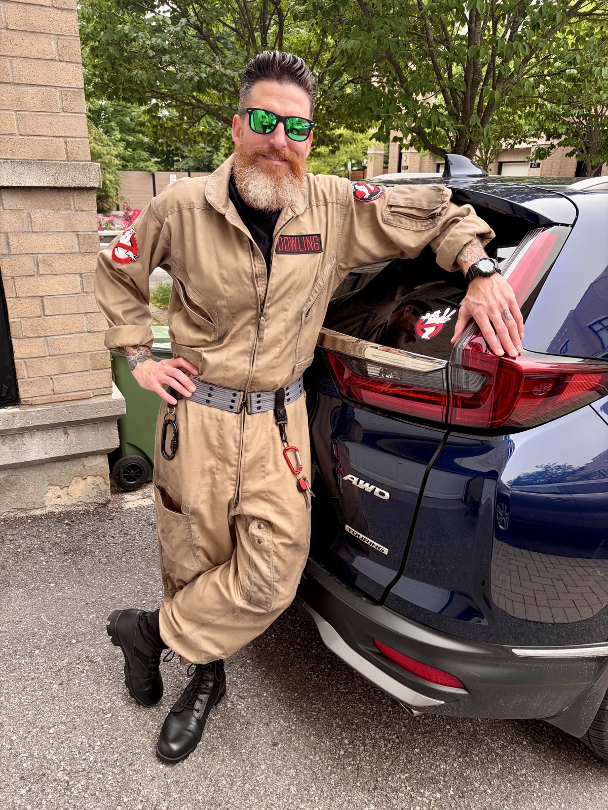 Ryan McFonz in a Ghostbusters flight suit leaning on a vehicle
