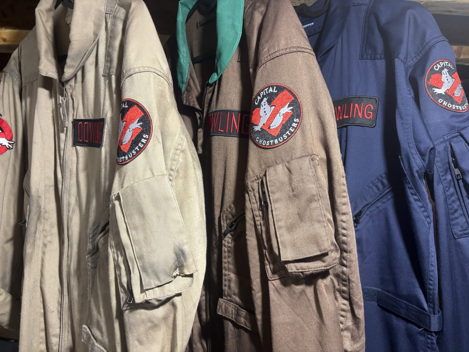 Capital Ghostbusters flight suits hanging with patches and name tapes